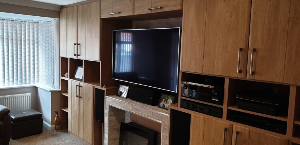 Winchester oak media wall with Grove doors, combining warmth and functionality in a bespoke design by Roy Newton Furniture in Staffordshire.