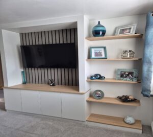 Media centre in white and oak. Grey oak acoustic panelling shows of the TV.